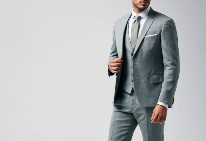 3 delig groen kostuum gecombineerd met een wit hemd, een groene das en een pochet