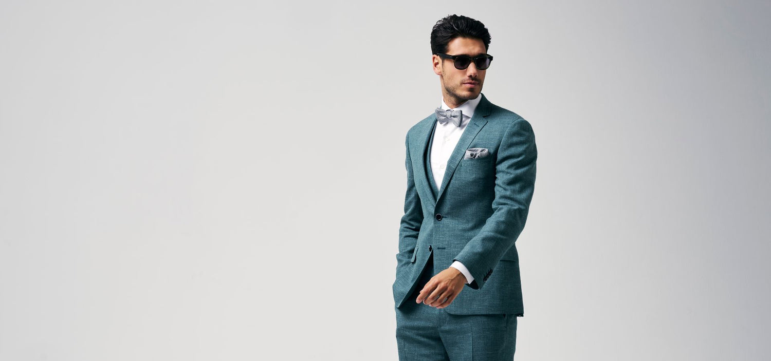 3 delig groen trouwkostuum in combinatie met een wit hemd en een strik en pochet in structuurstof in het groen